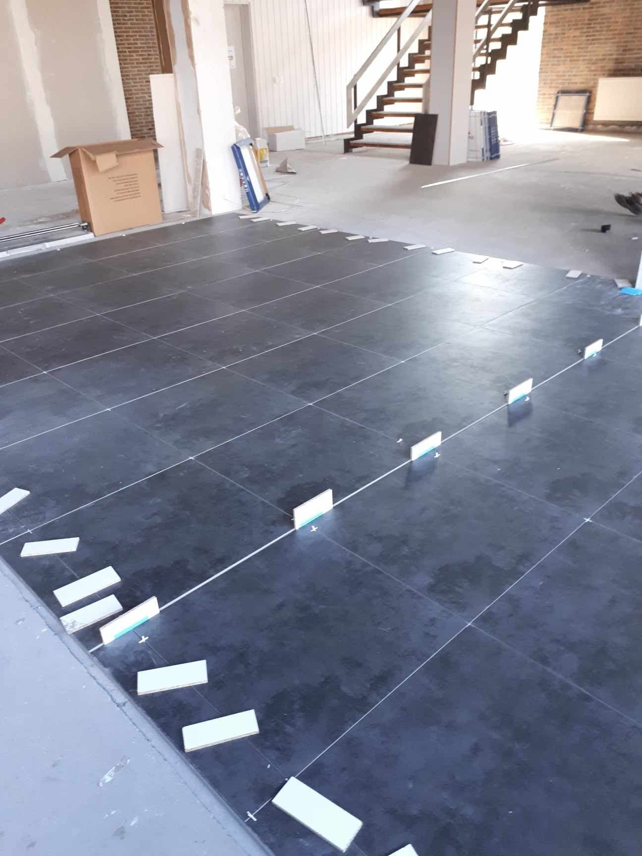 HOME-RENOVATION vakman aan het werk tijdens een tegelwerk-plaatsing